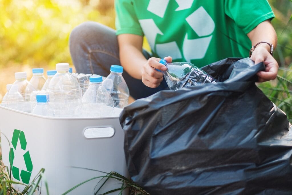 a woman picking up garbage plastic bottles into a 2024 12 04 12 16 35 utc