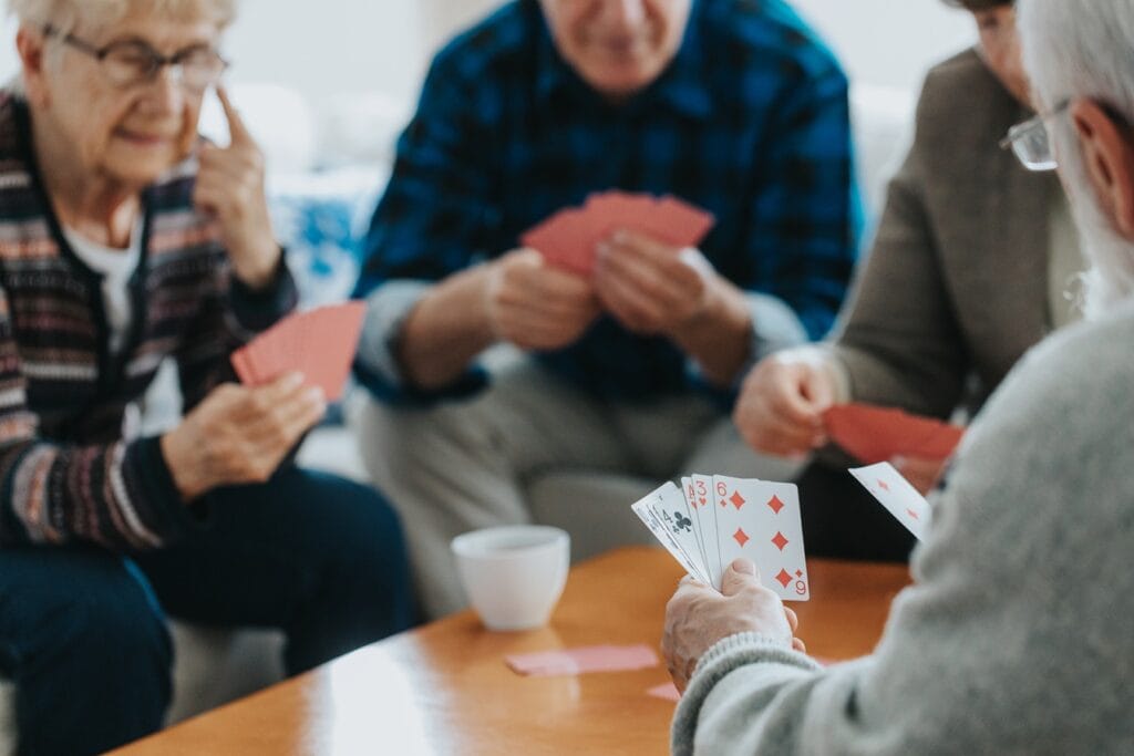 senior friends sit at a coffee table and play card 2026 03 10 03 12 05 utc