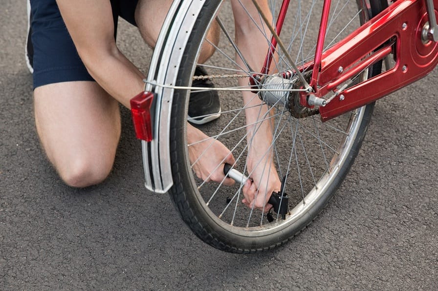 cropped view of young man kneeling inflating bicyc 2026 01 05 23 30 48 utc
