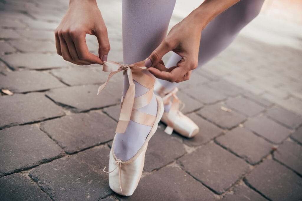 cropped shot of young ballerina tying pointe shoe 2026 03 12 23 56 56 utc