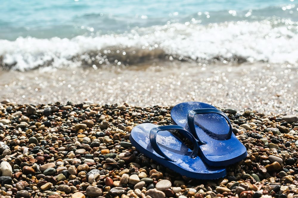 wet blue rubber flip flops at the pebbly beach 2026 03 09 23 15 28 utc