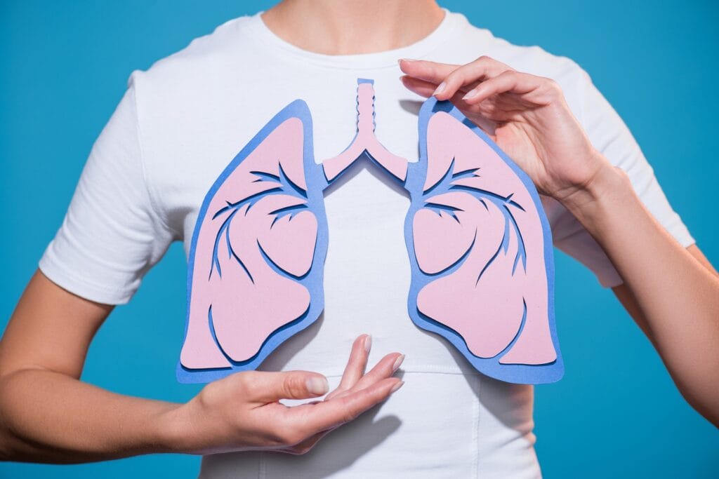 woman holding pink paper lungs on blue background 2026 09 21 05 35 36 utc
