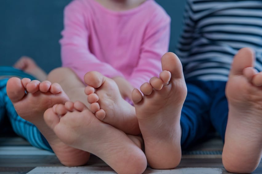 barefoot children relaxing indoors on wooden floor 2026 09 24 21 37 24 utc