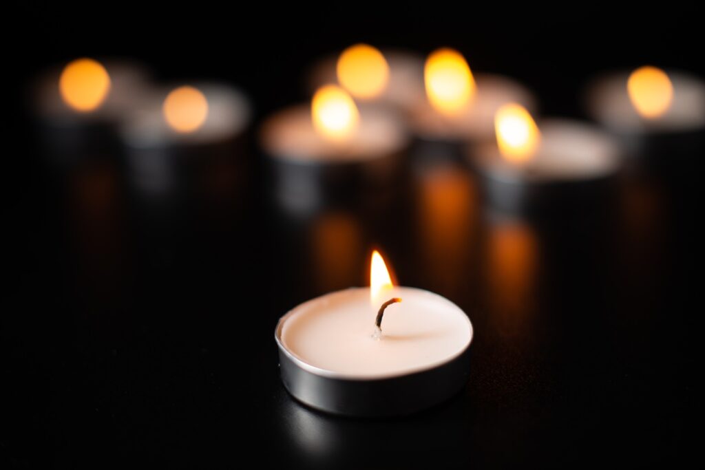 front view of burning candles on pitch black surfa 2026 09 23 12 42 49 utc